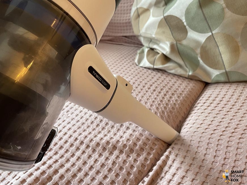 Die Couch wird mit einem Akkusuager abgesaugt.